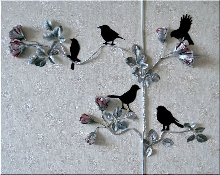 Провода питания телевизора на стене, украшенные цветами и искуственными птицами