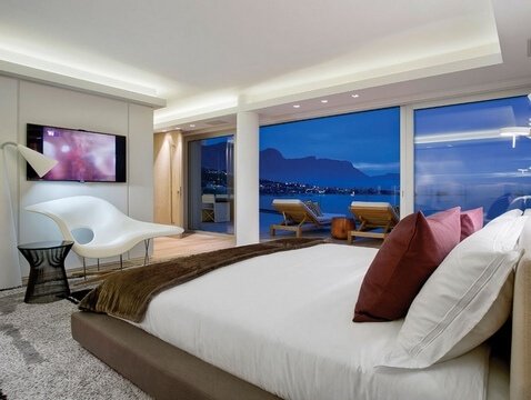 Фото телевизора на стене в красивой спальне с большим окном